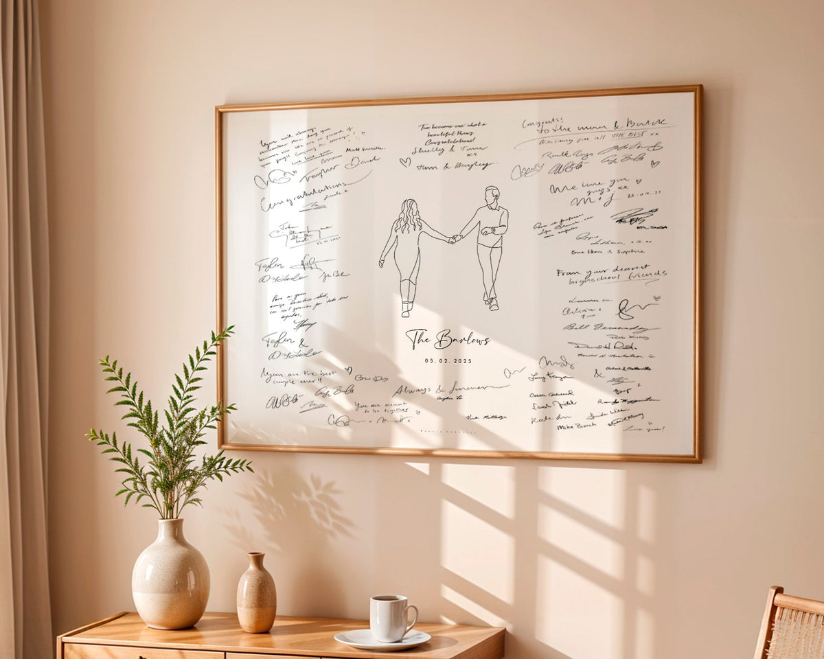 Framed artwork with a couple holding hands and signatures on a beige wall.
