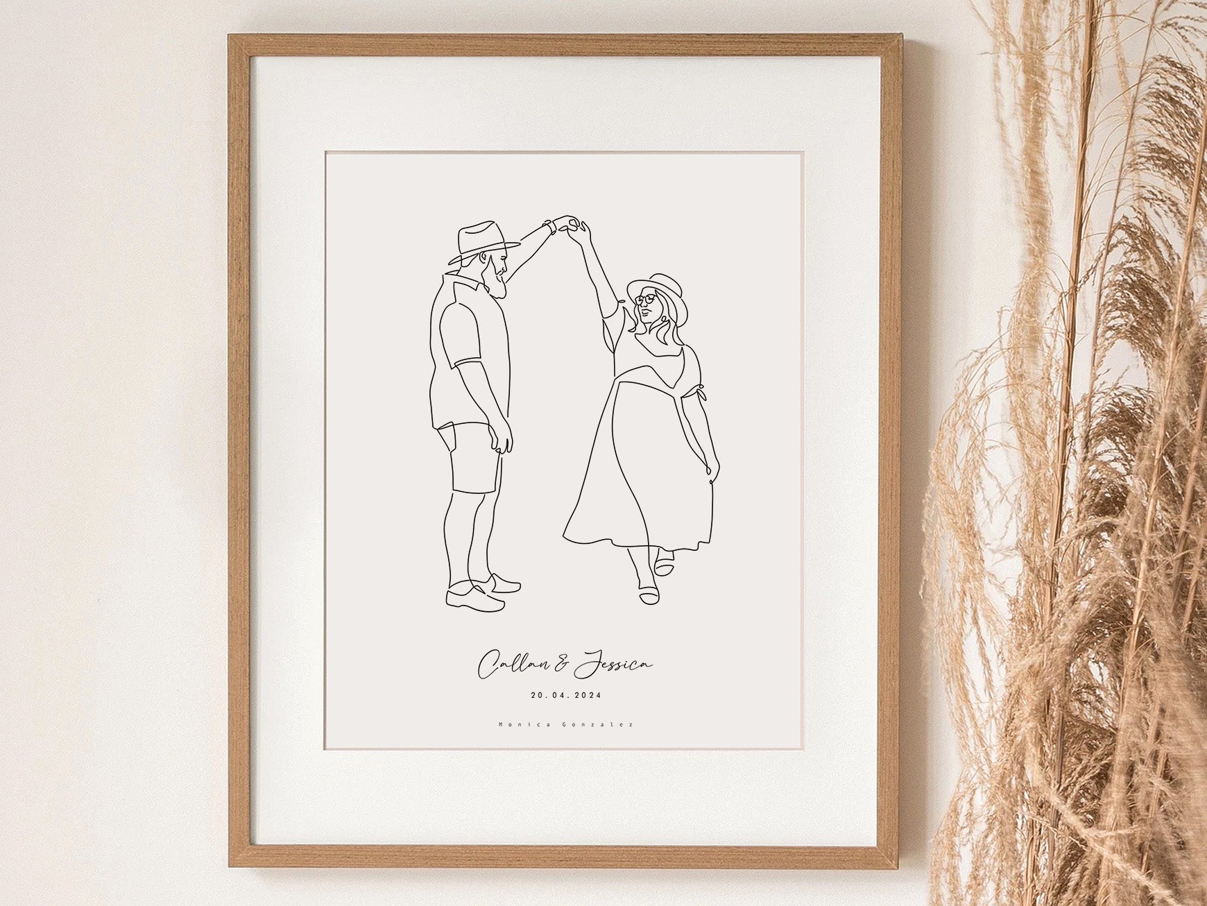 Framed line drawing of a couple on a white wall with decorative elements.