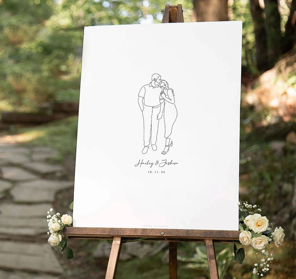 Line drawing of a couple on a white board welcome sign with floral decorations outdoors with wedding decorations